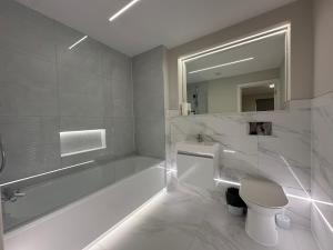 a bathroom with a tub and a toilet and a sink at Wendover Annexe in High Wycombe
