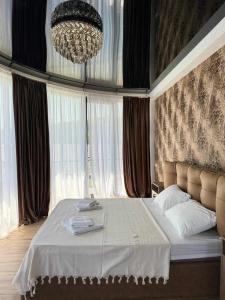 a bedroom with a large bed with a chandelier at Shato mash in Tbilisi City