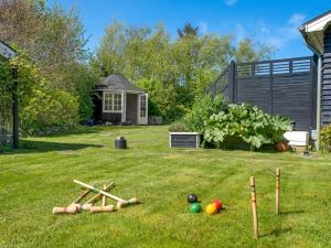Un grupo de bates y pelotas en un césped en Holiday Home Welma - 200m from the sea by Interhome, en Frederikshavn