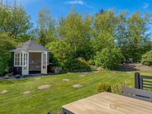 un patio trasero con cenador en el césped en Holiday Home Welma - 200m from the sea by Interhome, en Frederikshavn