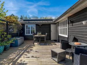 un patio de madera con mesa y sillas. en Holiday Home Welma - 200m from the sea by Interhome, en Frederikshavn 18 fotos más