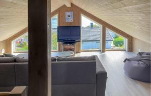 a living room with a couch and a tv at Lovely Home In Sandviga With House Sea View in Skarvedalen