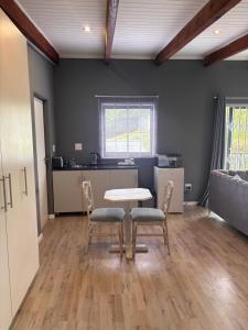 a room with a table and chairs and a kitchen at Hilton Splendour 1 in Hilton