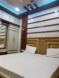 a bedroom with a large bed and a mirror at Kanha Guest House in Varanasi +7 photos