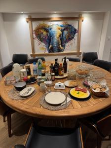 ein Tisch mit Essen und einem Gemälde eines Elefanten in der Unterkunft Chambre privée avec salle de bain in Domagné