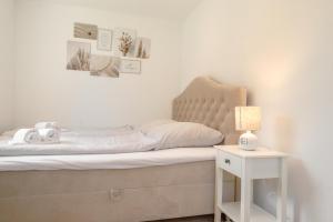 a bedroom with a bed and a nightstand with a lamp at Nordstrander Küstenlodge - Sternentraum in Nordstrand