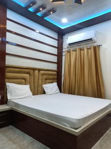 a bedroom with a large bed with a wooden headboard at Kanha Guest House in Varanasi