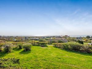 a green field with houses and a town in the background at Holiday Home Minza - 150m from the sea by Interhome in Knebel