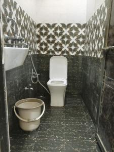 a small bathroom with a toilet and a sink at Kanha Guest House in Varanasi