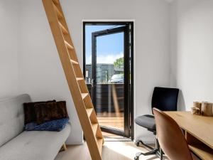 a room with a table and chairs and a ladder at Holiday Home Merve - 250m from the sea by Interhome in Odder +12 photos