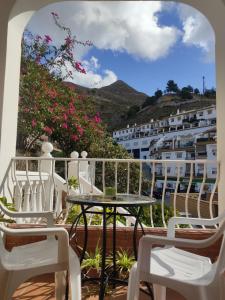 a balcony with a table and chairs and a building at Casa Arriate in Cómpeta