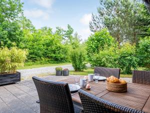 a wooden table with a basket of fruit on it at Holiday Home Rosaline - 500m from the sea by Interhome in Grenå