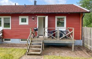 a red house with a porch with a table and chairs at Beautiful Apartment In Pauliström in Pauliström +12 photos