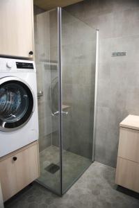 a shower stall with a washing machine in a bathroom at 3 Bedroom Nordic Timber Home in Kokkola