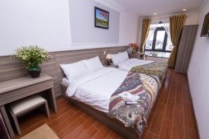 a hotel room with two beds and a desk and a desk at Lina Hotel in Khu Chi Lăng