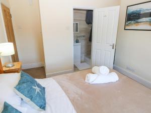 ein Schlafzimmer mit einem Bett mit Handtüchern darauf in der Unterkunft Hawthorns in Knelston + 27 Fotos
