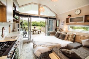a bedroom with a bed and a couch and a kitchen at Hillside Lodge in Nantmel