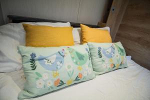a bed with three pillows on it at Hillside Lodge in Nantmel