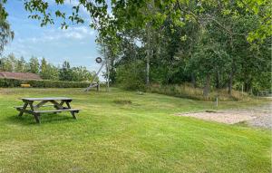 a picnic table sitting in the grass in a park at Beautiful Apartment In Pauliström in Pauliström