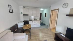 a kitchen and living room with a table and a couch at Apartman Mario in Tomislavgrad