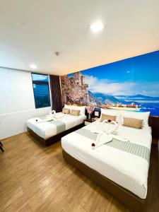 two beds in a hotel room with a large window at Swiss Hotel at City Centre in Kuala Lumpur +31 photos