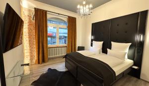 a bedroom with a bed with a black headboard and a window at Historical Luxury Homes - Luxus Loft Wallstreet in Freiburg im Breisgau