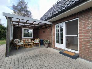 a patio with chairs and awning on a house at FeWo Unter den Linden in Wallsbüll