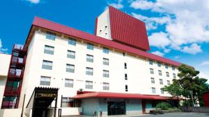 a large white building with a red roof at LiVEMAX Resort Echigo Yuzawa in Yuzawa