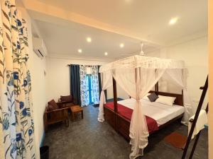 a bedroom with a bed with a canopy at Villa Komalee in Unawatuna +25 photos