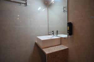 PrayagrajにあるHotel Aromaの洗面台と鏡のあるバスルーム