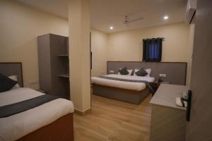 PrayagrajにあるHotel Aromaのベッド2台と机があるホテルの部屋