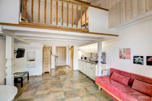 un salon avec un canapé rouge et une cuisine dans l'établissement GUT Edelweiss, à Kaprun