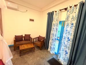 sala de estar con sillas, mesa y cortinas en Villa Komalee, en Unawatuna