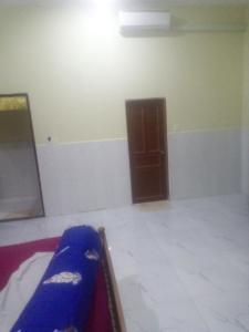 a room with a bed and a wooden door at Homestay Srey Mom in Kampot