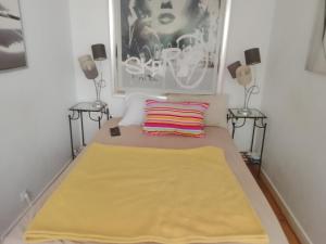 ルヴァロワ・ペレにある5 minute Eiffel tour and Louvre meysm ,aewsome appartement 2 bed , center ,gorgeous placeの黄色の毛布が敷かれたベッド1台