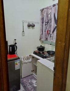 a small kitchen with a stove and a sink at Studio Meublé Yassa in Douala