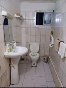 a white bathroom with a toilet and a sink at Studio Meublé Yassa in Douala