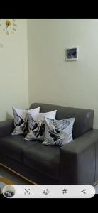 a black couch with several pillows on it at Studio Meublé Yassa in Douala