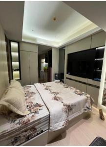a bedroom with a large bed and a flat screen tv at Aldrich axelle pollux in Bagam