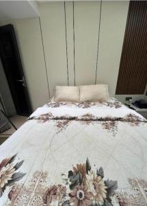 a bedroom with a bed with a flower blanket on it at Aldrich axelle pollux in Bagam