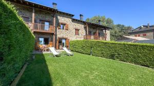 a house with two lawn chairs in front of it at Guils Cal Peiró in Guils de Cerdaña