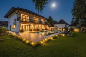 a large house with a swimming pool at night at Eden Villa A Tropical Paradise Pool Villa in Rawai Beach
