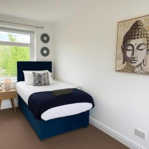 Un dormitorio con una cama azul con un retrato de una mujer. en Contractors, Private Driveway for Multiple cars, Wifi, Long Stay, en Washington