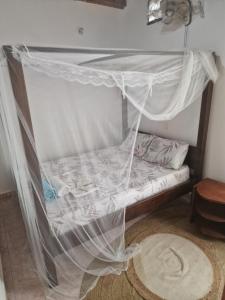 a bed with mosquito netting over it in a room at Diani Beach Relax in Diani Beach