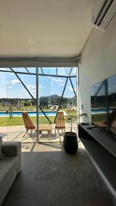 パラグアリにあるVilla Toscanaのリビングルーム(ソファ、椅子付)、プールが備わります。