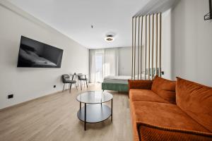 a living room with a couch and a table at 1,5 room AC apartment, balcony,new building, Downtown, Old City in Nivy