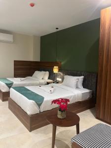 a bedroom with two beds and a green wall at NOMAD PYRAMIDS AND SPHINX Hotel in Cairo +50 photos