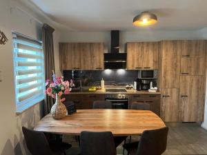 a kitchen with a wooden table with a vase of flowers at Appartements Bergliebe in Bichlbach