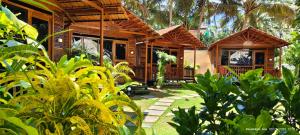 a wooden house with a porch and some plants at Abba's Glory Land - Agonda in Agonda