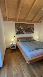 a bedroom with a large bed and two lamps at Grüne Gams - Neubau Designwohnung mit 2 Balkonen in Breitbrunn am Chiemsee +45 photos